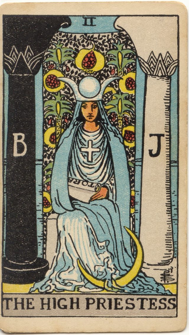 The High Priestess: The black and white pillars, the veil of palms and pomegranates, the horned crown, the tora scroll. Rider–Waite–Smith tarot, 1909.